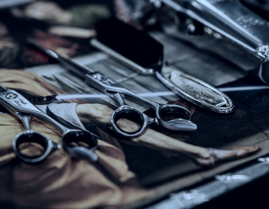 Professional barber shears, laid out on a tool roll